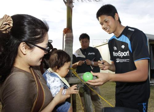 練習後に赤ちゃんにサイン入りゴムボールを渡す日本ハム・大谷