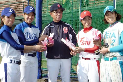 練習に参加した日本女子プロ野球リーグの三浦伊織外野手（右から２人目）らから、バレンタインデーのお菓子を贈られた中日・高木監督（中央）