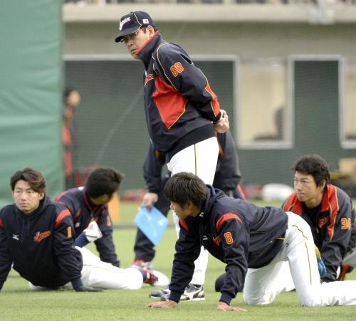 屋内練習場でストレッチする選手を見詰めるＷＢＣ日本代表の山本監督（中央）