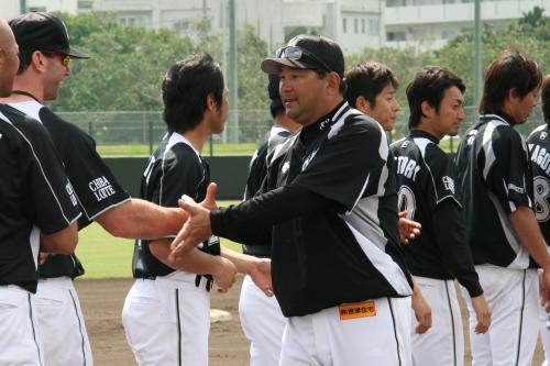石垣島キャンプを打ち上げ、選手やスタッフら全員と握手をするロッテ・伊東監督（中央）