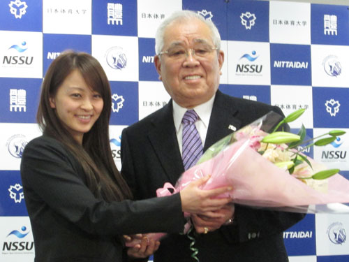 日体大研究員でロンドン五輪体操女子代表の田中理恵（左）から花束を受け取る野村氏はデレデレ