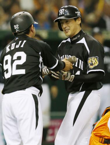 ６回に本塁打を放ち、久慈コーチ（左）からバットを受け取り笑顔を見せる阪神・能見