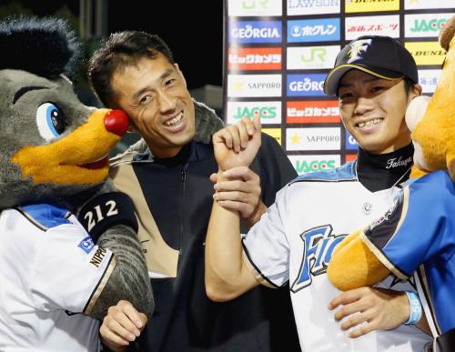 ８勝目を挙げ、お立ち台で笑顔の日本ハム・木佐貫（左）と勝ち越し打の中島