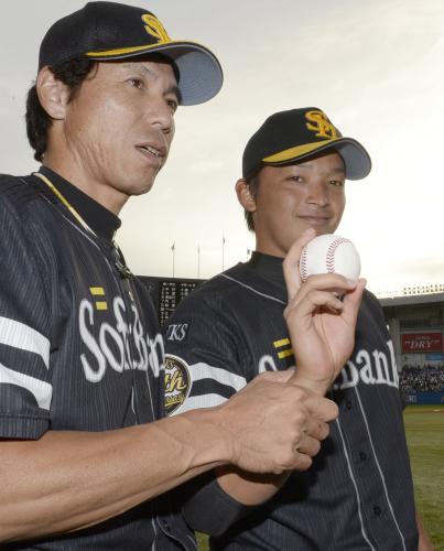 プロ初勝利を挙げ、ウイニングボールを手に秋山監督（左）とポーズをとるソフトバンク・東浜