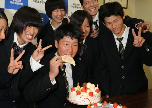 お祝いのケーキを贈られた渡辺は「日本ハム　諒」と書かれたチョコをガブリ。後ろでクラスメイトが祝福