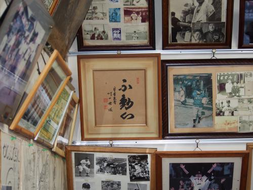 小池商店の店内に飾られる川上さん直筆の「不動心」の額と写真　