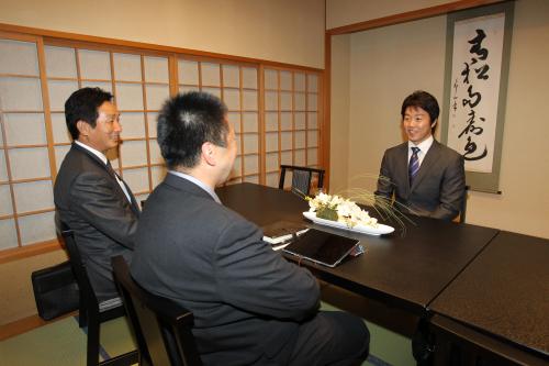 ソフトバンクの小川一夫編成育成部長（左）、小林至海外兼中長期戦略担当部長（右）と笑顔で話す鶴岡