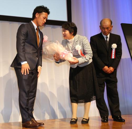 ゴールデン・ルーキー賞の懇親会壇上で母・弘子さん、父・吉弘さんに花束を渡すヤクルト・小川
