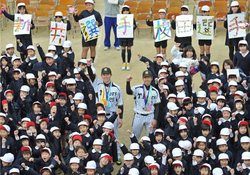小学校を訪問し、記念写真におさまる阪神・新井（中央左）と榎田