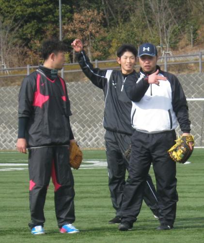 三塁守備に今季挑戦する阪神・今成（左）は日本ハム・小谷野（右）からノック中に守備のアドバイスを受ける