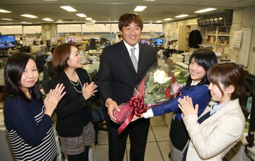 スポニチ本紙評論家に決まった石井一久氏は女性社員から花束を受け取り笑顔