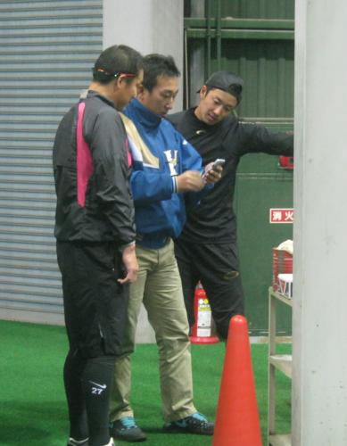 日本ハム・斎藤（右）はブルペン投球後、畑中広報（中）が撮影した動画を中嶋バッテリーコーチとのぞき込む