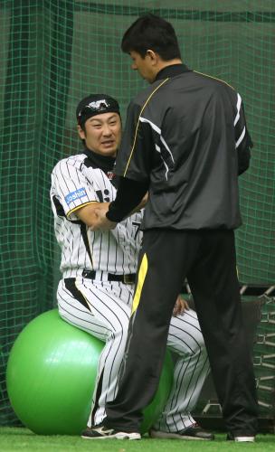 権田トレーナー（右）に右ひじのチェックを受ける西岡