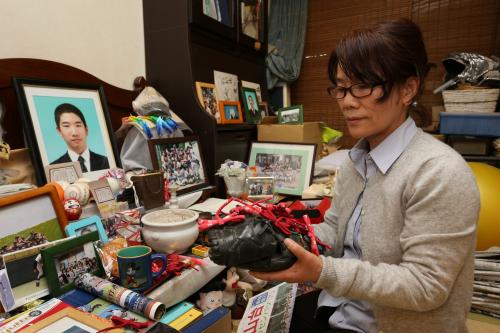 エレベーター事故で亡くなった市川大輔さんの遺影に手作りの赤とんぼとグラブを手にしセンバツ出場を報告する母・正子さん