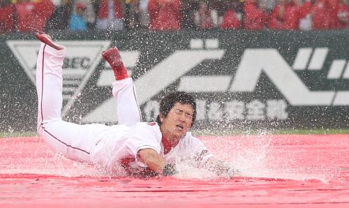 ＜広・日＞広島・上本は雨で試合がコールドになり恒例の雨中スライディングを披露する