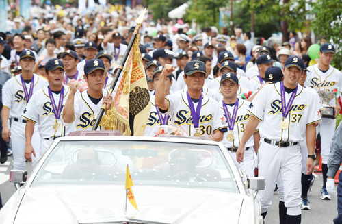 大垣市で行われた祝賀パレードでガッツポーズをする西濃運輸の林監督（手前右）と麻生主将（同左）