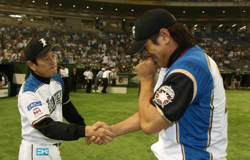 ＜日・ソ＞東京ドームでの現役最後の試合を終え涙しながら栗山監督（左）と握手する稲葉