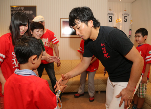 招待した子供と握手する松田（右）