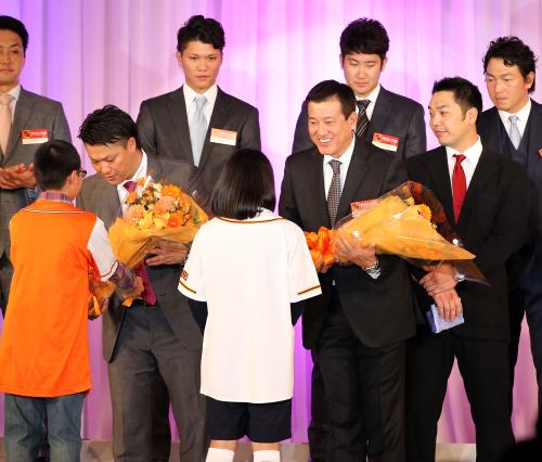 小学生のファンから花束贈呈され笑顔を見せる村田（左）と原監督（中央）。右は阿部