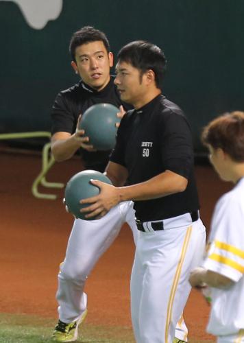 ＜ソフトバンク＞メディシングボールを使い練習する大隣（左）と摂津