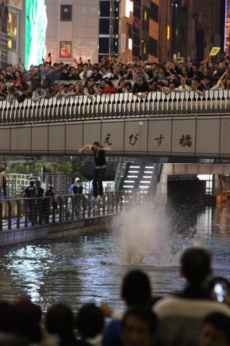 １８日、タイガースの日本シリーズ進出決定を喜ぶ人たちが、戎橋から道頓堀川に飛び込む