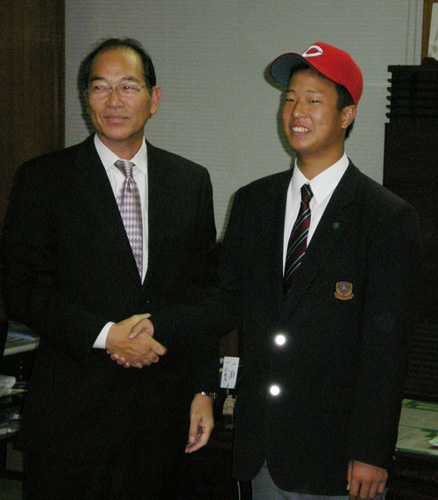 広島の帽子をかぶり、白武スカウト部長（左）と握手する広島のドラフト３位・塹江