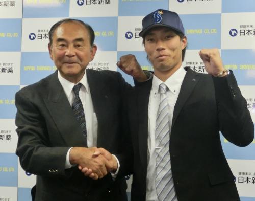 吉田スカウト部長（左）と握手する倉本