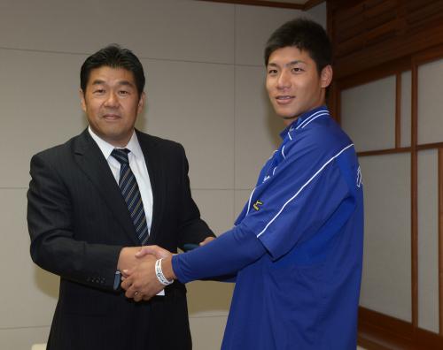 加藤球団副本部長兼編成部長（左）と笑顔で握手するＮＴＴ東日本・高木