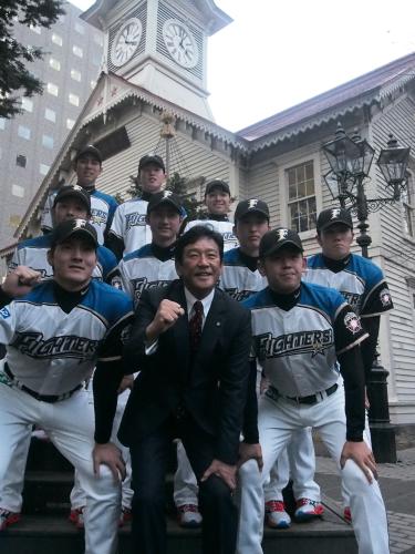 札幌市時計台の前でポーズを取る日本ハムドラフト指名９選手と栗山監督（手前中央）