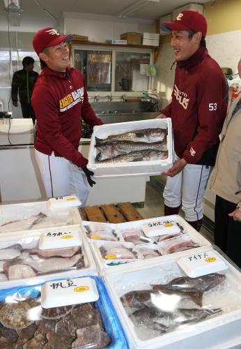 鹿折復興マートを訪れた松井裕（左）と相原は鱈を手に笑顔を見せる