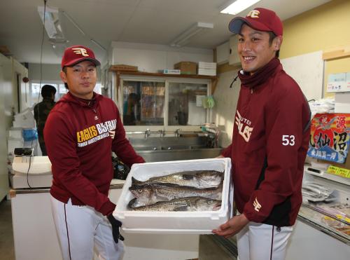 鹿折復興マートを訪れた松井裕（左）と相原は鱈を手に笑顔を見せる