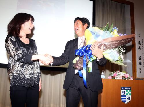 特別講義を終え、長島三奈さん（左）から花束を手渡された栗山監督は笑顔で握手を交わす