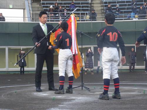 「第５回田中浩康カップ」閉会式で、優勝した新富少年スポーツ団に優勝旗を手渡すヤクルト・田中浩（左）