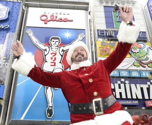 サンタクロース姿で登場し、グリコ看板の前でランナーのポーズをとる元阪神タイガースのランディ・バースさん