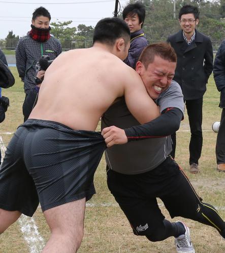 柔道で県大会３連覇中の崎原さん（左）と相撲を取る大隣