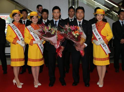 那覇空港で、てだこレディから花束を受け取るヤクルト・雄平（左）と真中監督
