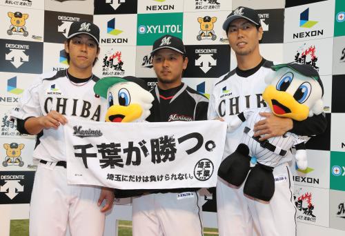＜ロ・西＞お立ち台に上がってライバル対決記念タオルの「千葉が勝つ」を持つ（左から）鈴木、田村、古谷