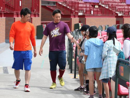 コボスタ宮城の中を歩いている途中にスタジアム見学の小学生から握手を求められる松井裕。左は福田