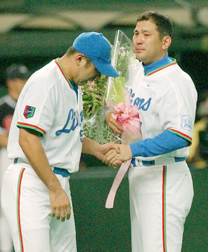 ０３年、現役を引退する西武・伊東（右）に花束を渡す和田