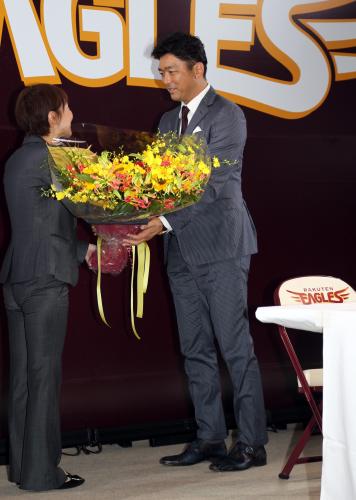 会見を終えた斎藤隆は球団職員から花束を贈られる