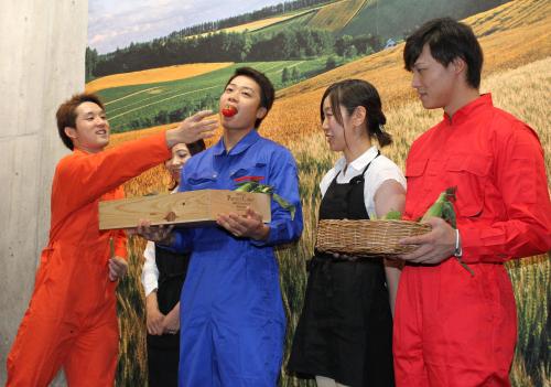 試合前、農作業着で中島（中央）にトマトを食べさせる杉谷（左）。右は石川慎