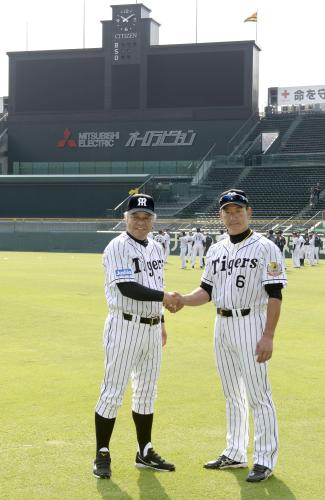 現役時代と同じ背番号のユニホーム姿で甲子園球場に現れ握手する、阪神の金本監督（右）と掛布２軍監督