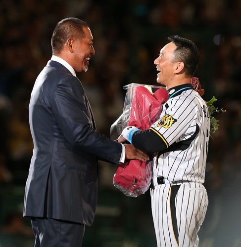 １２年、金本氏（右）の引退試合で清原氏が花束を渡す