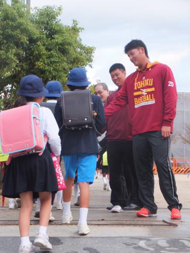 キャンプ２度目の休日で倉敷市立万寿東小学校で登校する児童をハイタッチで出迎える楽天の安楽（右端）と加藤（右から２番目）