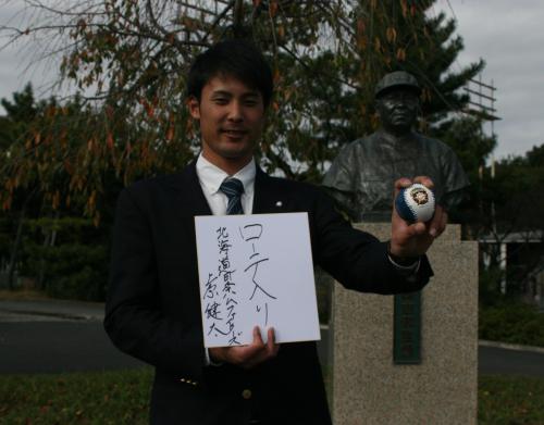 日本ハムと仮契約を結び、島岡吉郎元監督の銅像前で「ローテ入り」の色紙を掲げる明大・上原