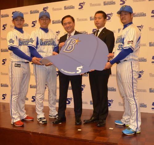 ５周年ロゴ入りの帽子のボードを持つ（左から）山崎康、三浦、黒岩・神奈川県知事、池田社長、後藤