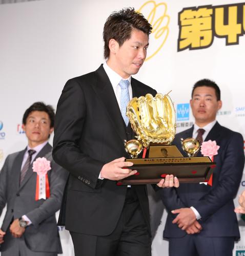 ゴールデン・グラブ賞を受賞した前田健はトロフィーを受けとる