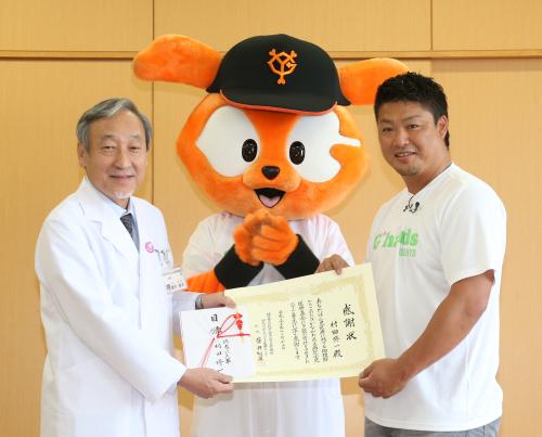 神奈川県立こども医療センターの康井総長（左）に医療寄付の目録を手渡し感謝状を受け取る村田