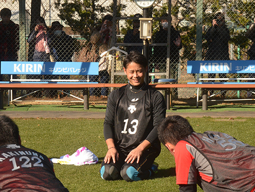 グラウンドの外で多くのファンが見守る中、トレーニング中に笑顔を見せる平沢