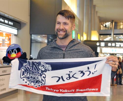 来日し、球団グッズを手にポーズをとるヤクルトの新外国人デイビーズ＝成田空港